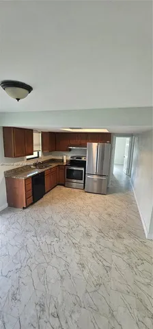 a large kitchen with kitchen island a stove and a sink