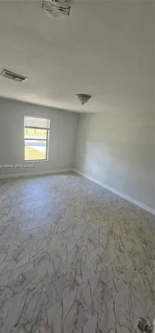 an empty room with a chandeliers fan