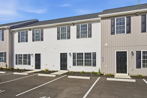 a front view of a house with a parking space