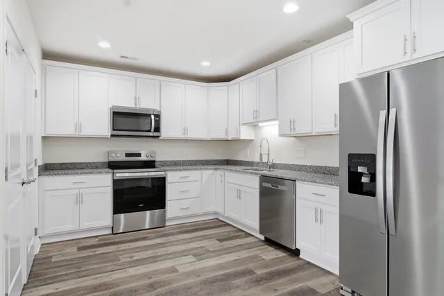 a kitchen with stainless steel appliances granite countertop a stove a sink and a refrigerator