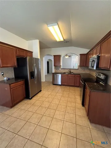 a kitchen with stainless steel appliances a refrigerator and a stove
