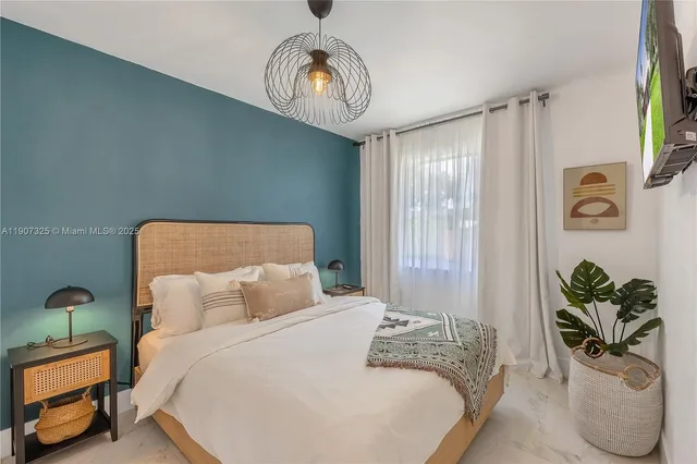 a bedroom with a bed and a chandelier