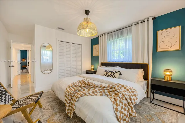 a bedroom with a bed and a chandelier