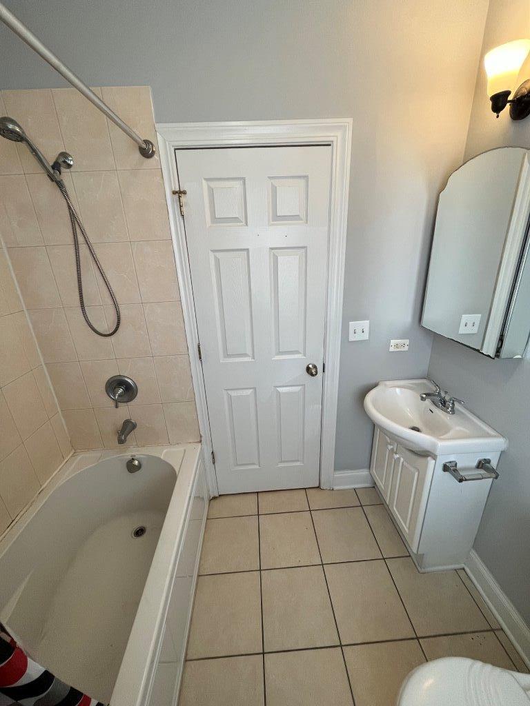 4548 West George Street, Unit 3 Chicago, IL 60641 - Photo 12 of 12 a bathroom with a granite countertop sink a toilet and shower