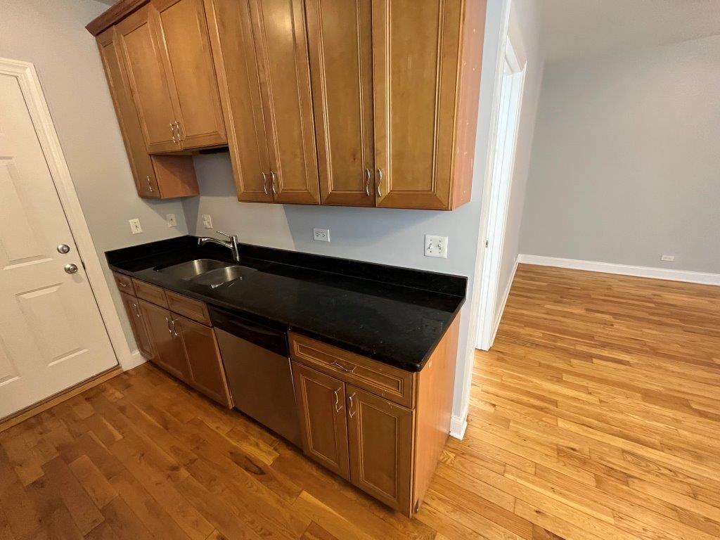 4548 West George Street, Unit 3 Chicago, IL 60641 - Photo 3 of 12 a kitchen with granite countertop a sink a stove and cabinets
