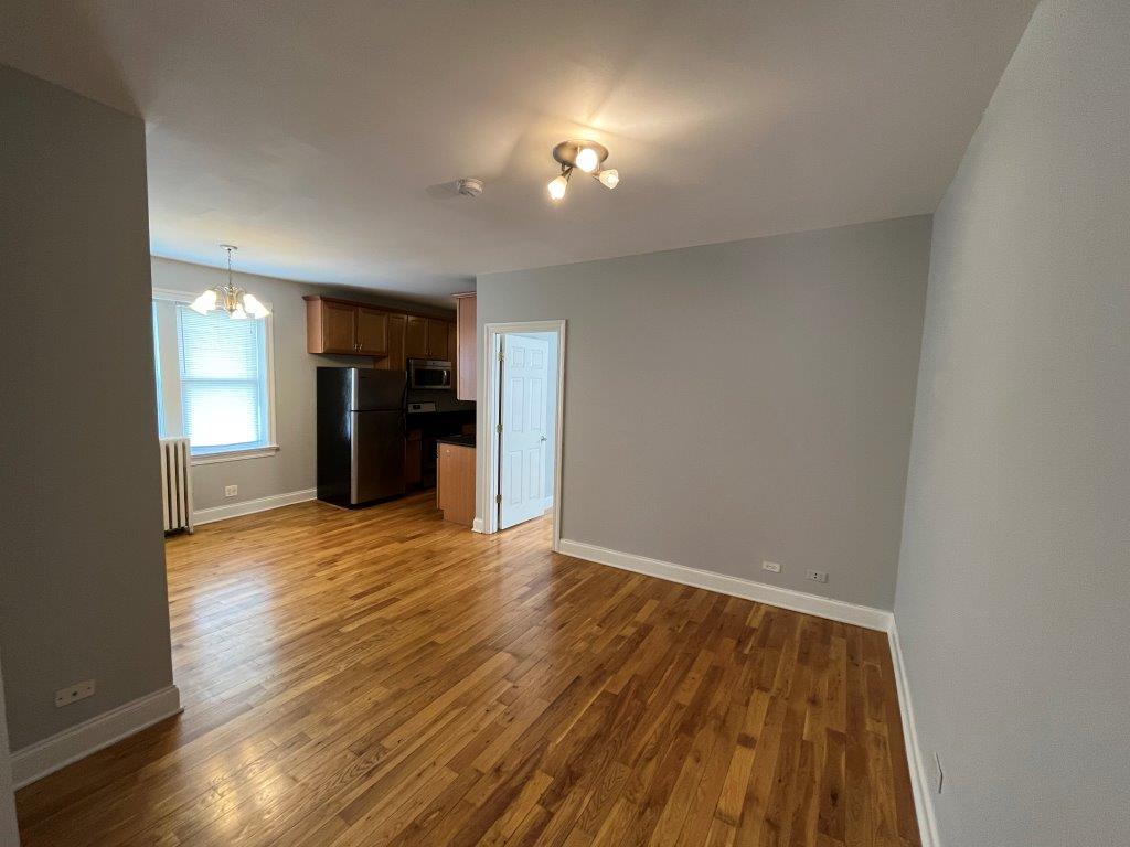 4548 West George Street, Unit 3 Chicago, IL 60641 - Photo 5 of 12 a view of an empty room with wooden floor and a window