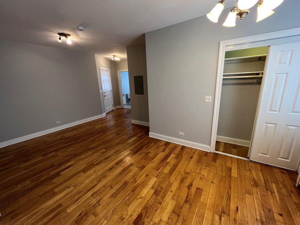 4548 West George Street, Unit 3 Chicago, IL 60641 - Photo 6 of 12 wooden floor in an empty room with a window