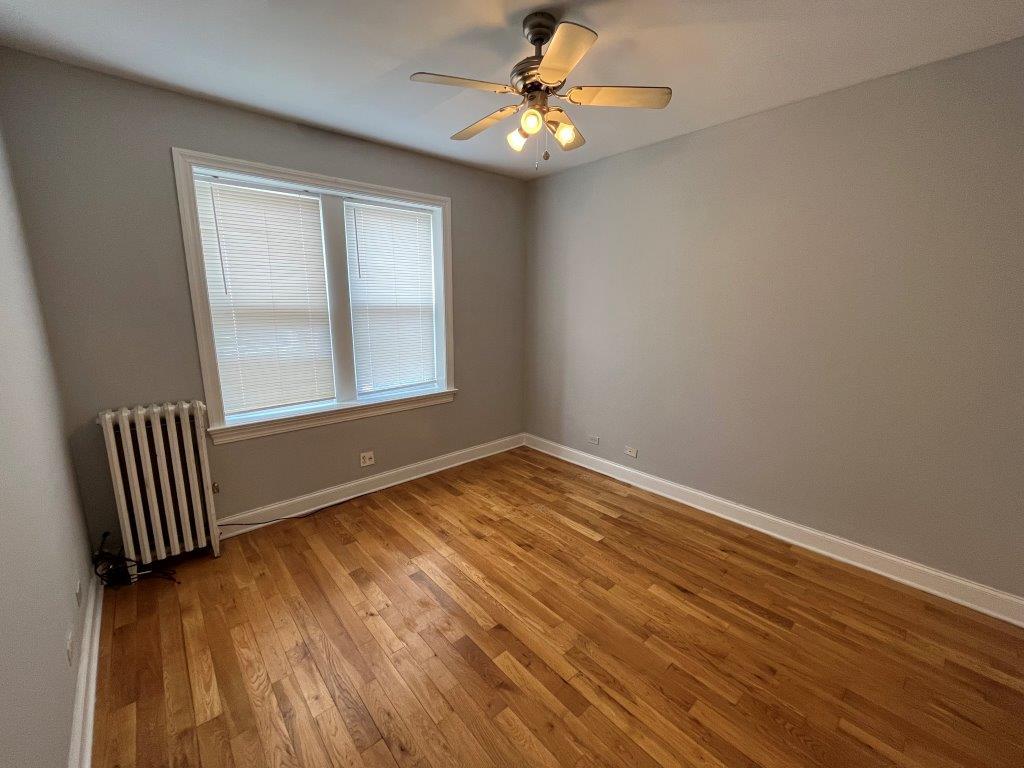 4548 West George Street, Unit 3 Chicago, IL 60641 - Photo 7 of 12 wooden floor in an empty room with a window