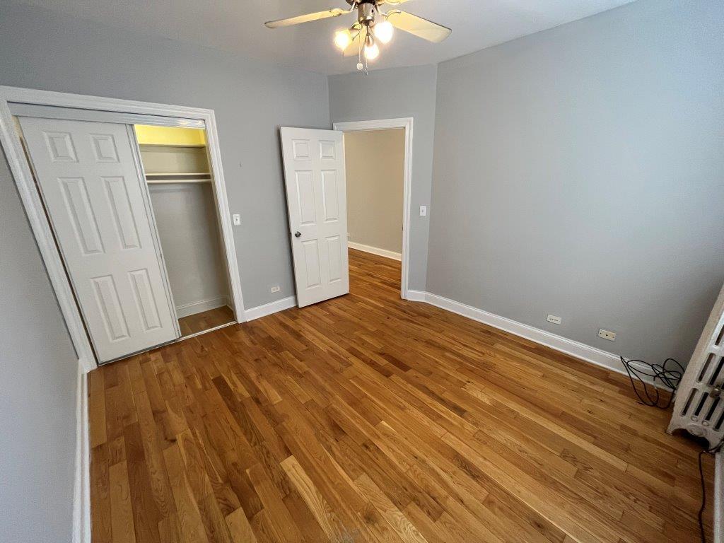 4548 West George Street, Unit 3 Chicago, IL 60641 - Photo 8 of 12 a bedroom with a bed and a chandelier