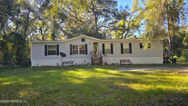 a front view of a house with yard and green space