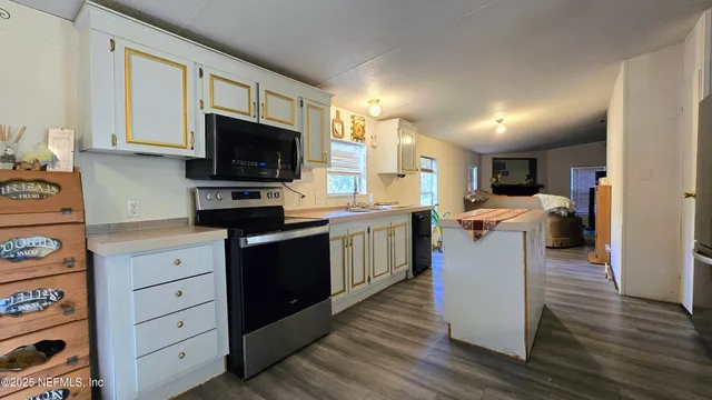 a kitchen with a sink a microwave and cabinets