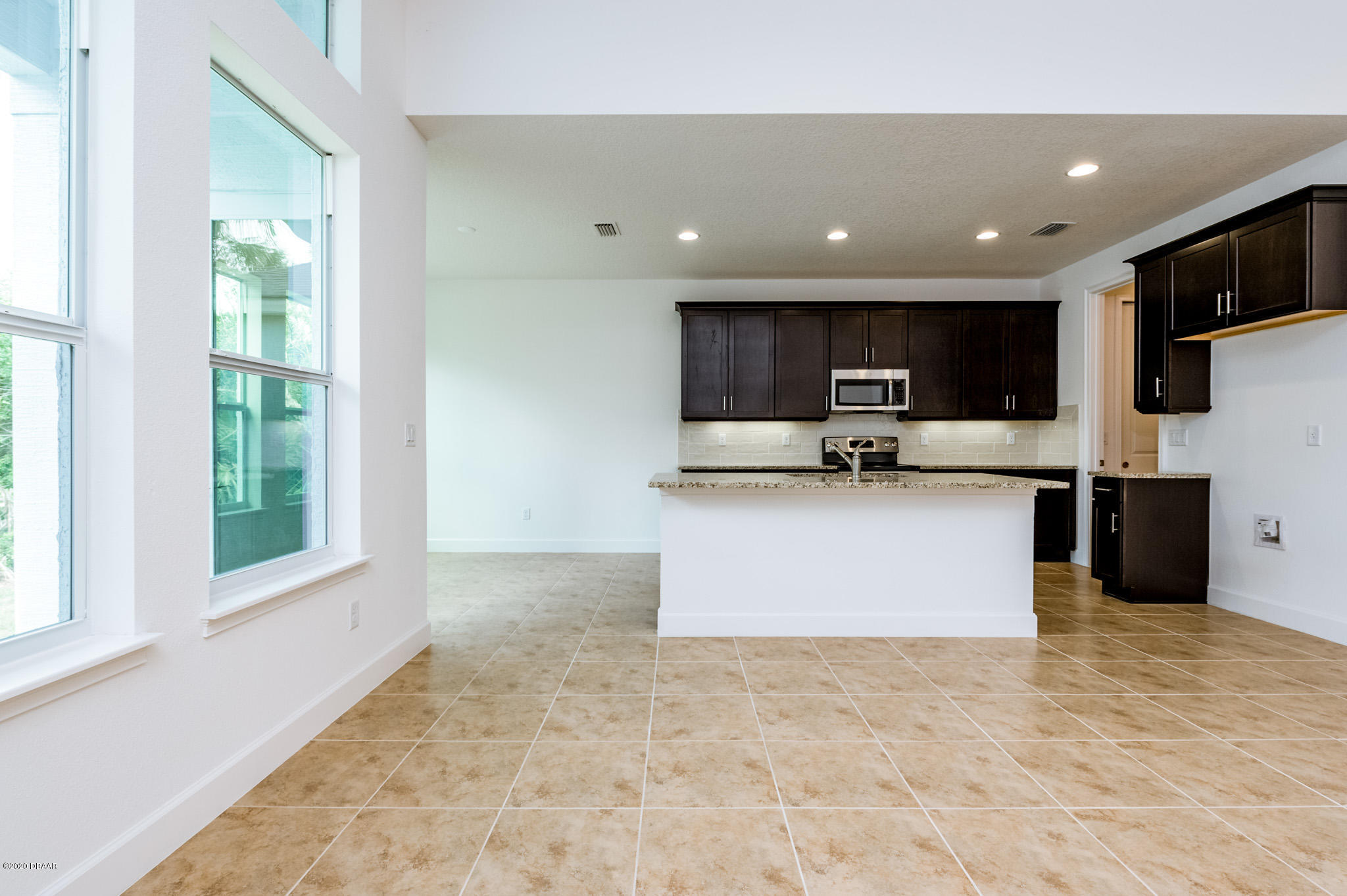 1851 Oak Place Flagler Beach, FL 32136 - Photo 17 of 31 a large kitchen with stainless steel appliances kitchen island granite countertop a stove top oven a sink and a granite counter top