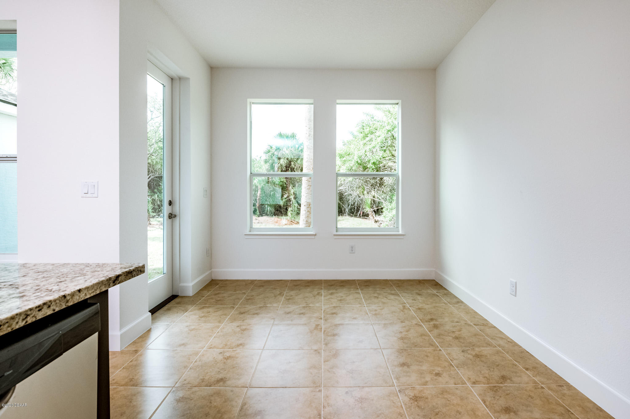 1851 Oak Place Flagler Beach, FL 32136 - Photo 19 of 31 an empty room with a kitchen island wooden floor and a window