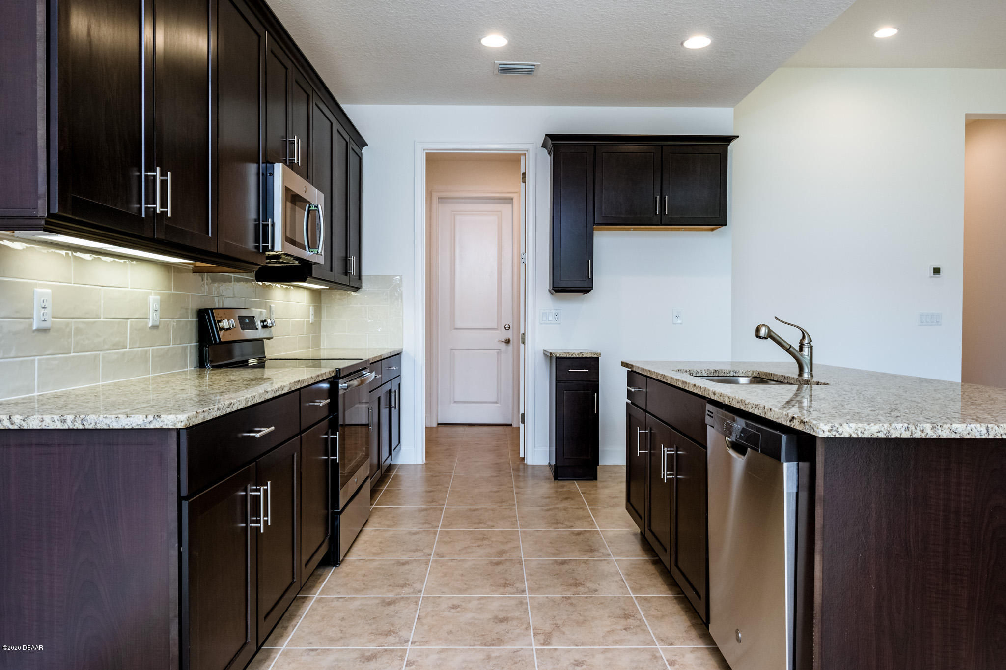 1851 Oak Place Flagler Beach, FL 32136 - Photo 20 of 31 a kitchen with stainless steel appliances granite countertop a sink a stove top oven a refrigerator and dishwasher