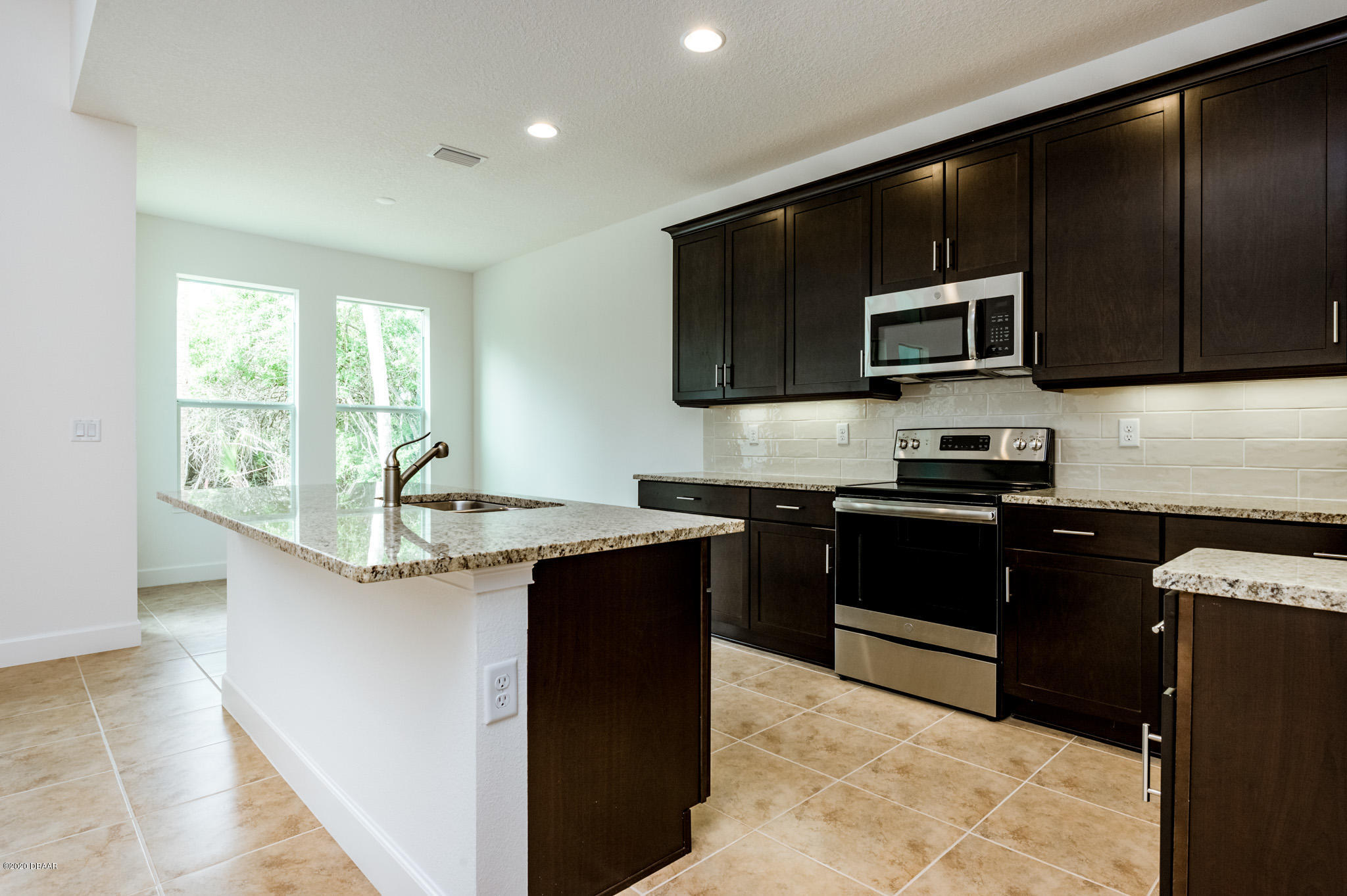 1851 Oak Place Flagler Beach, FL 32136 - Photo 27 of 31 a kitchen with stainless steel appliances granite countertop a stove a sink and a microwave