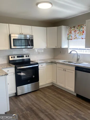 a kitchen with stainless steel appliances white cabinets and a sink