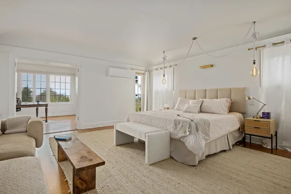 a spacious bedroom with a bed a couch and window