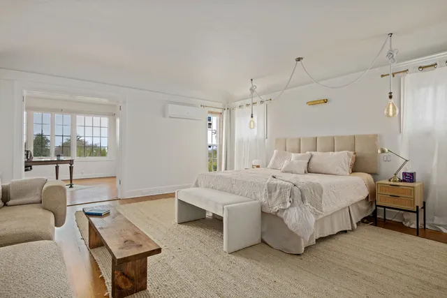 a spacious bedroom with a bed a couch and window