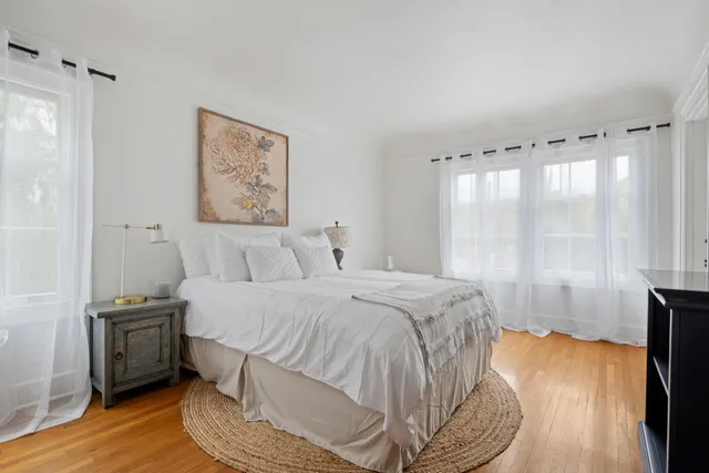 a bed sitting in a bedroom next to a window