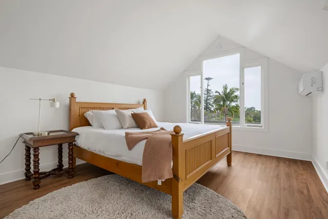 a bed sitting in a bedroom next to a window