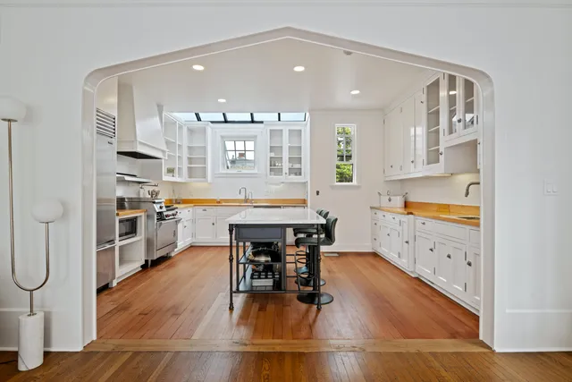 a kitchen with stainless steel appliances kitchen island granite countertop a stove a sink and a refrigerator