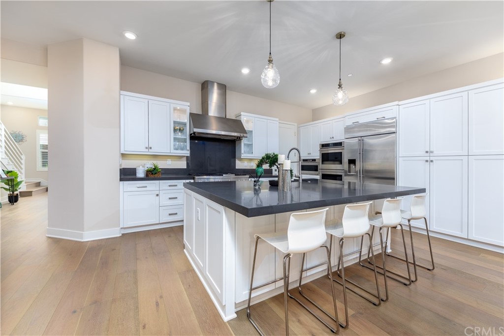 a kitchen with kitchen island granite countertop a sink a counter space appliances and cabinets