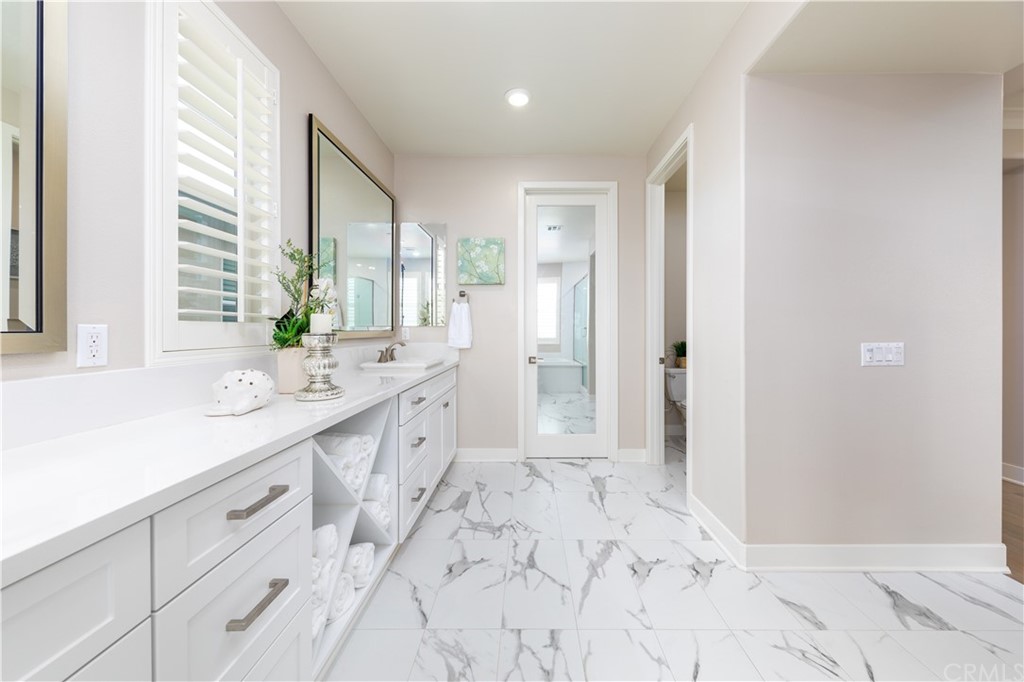 56 Swift Irvine, CA 92618 - Photo 19 of 43 a spacious bathroom with a double vanity sink a large mirror a bathtub and next to a window