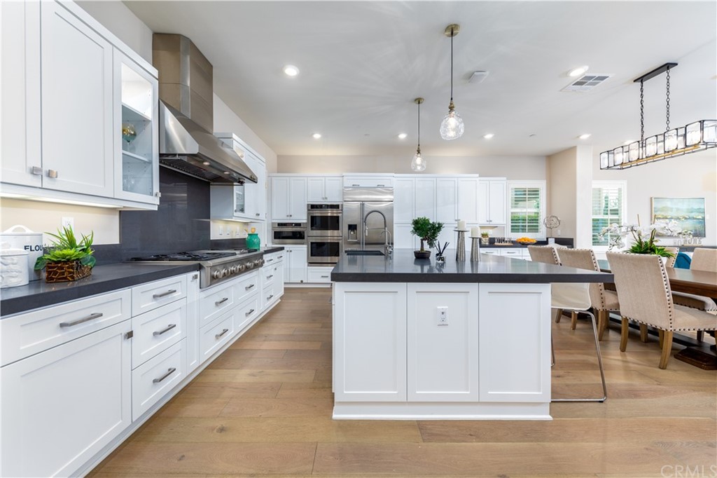 56 Swift Irvine, CA 92618 - Photo 2 of 43 a kitchen with stainless steel appliances granite countertop a refrigerator a sink dishwasher and white cabinets with wooden floor
