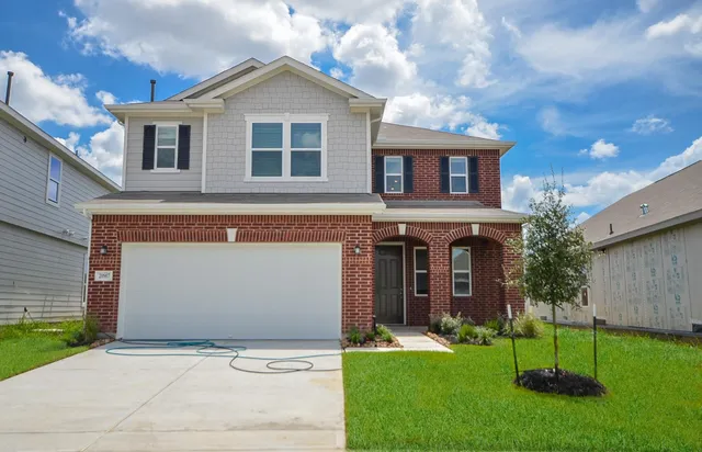 a front view of a house with a garden and yard