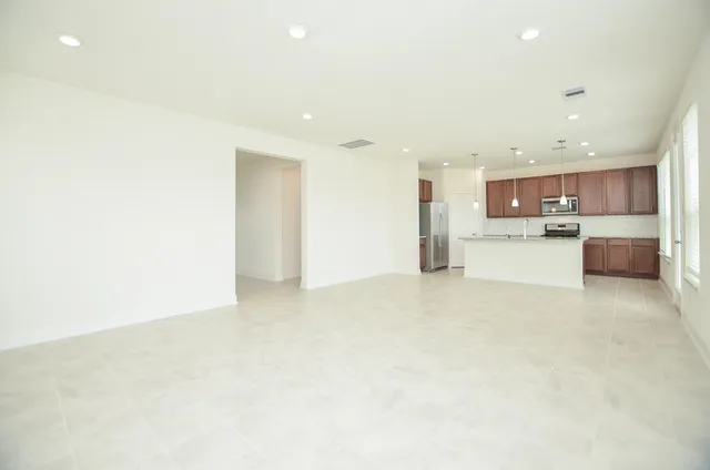 a view of kitchen with kitchen island and stainless steel appliances