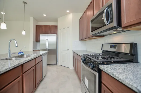 a kitchen with a sink chandelier and refrigerator