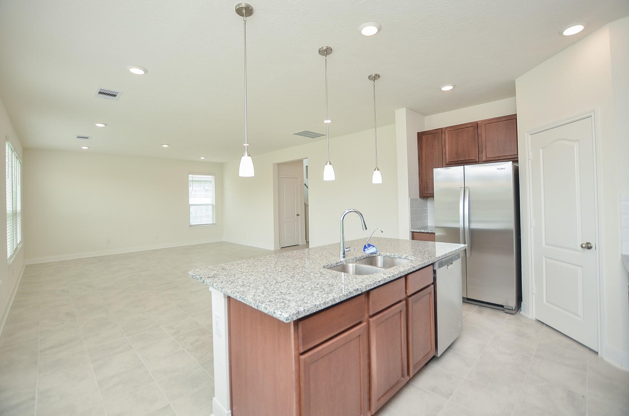 20907 Filbert Lane Katy, TX 77449 - Photo 17 of 43 a kitchen with a sink chandelier and refrigerator
