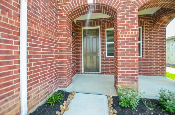 a view of a brick house with plants