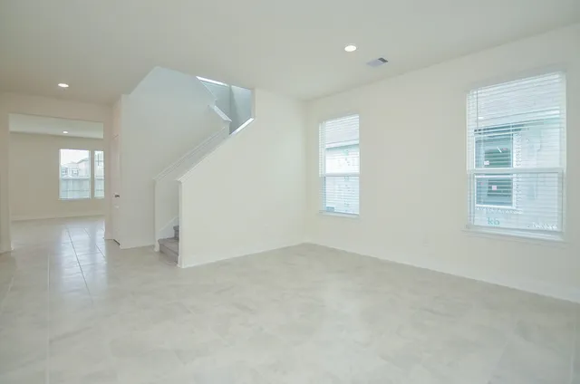 an empty room with windows and entrance to other room