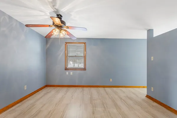 a view of a room with wooden floor and fan