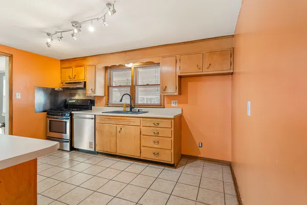 a kitchen with granite countertop a sink stainless steel appliances and cabinets