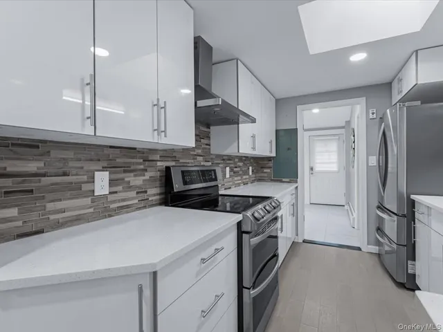 a kitchen with stainless steel appliances granite countertop a refrigerator a stove and a sink