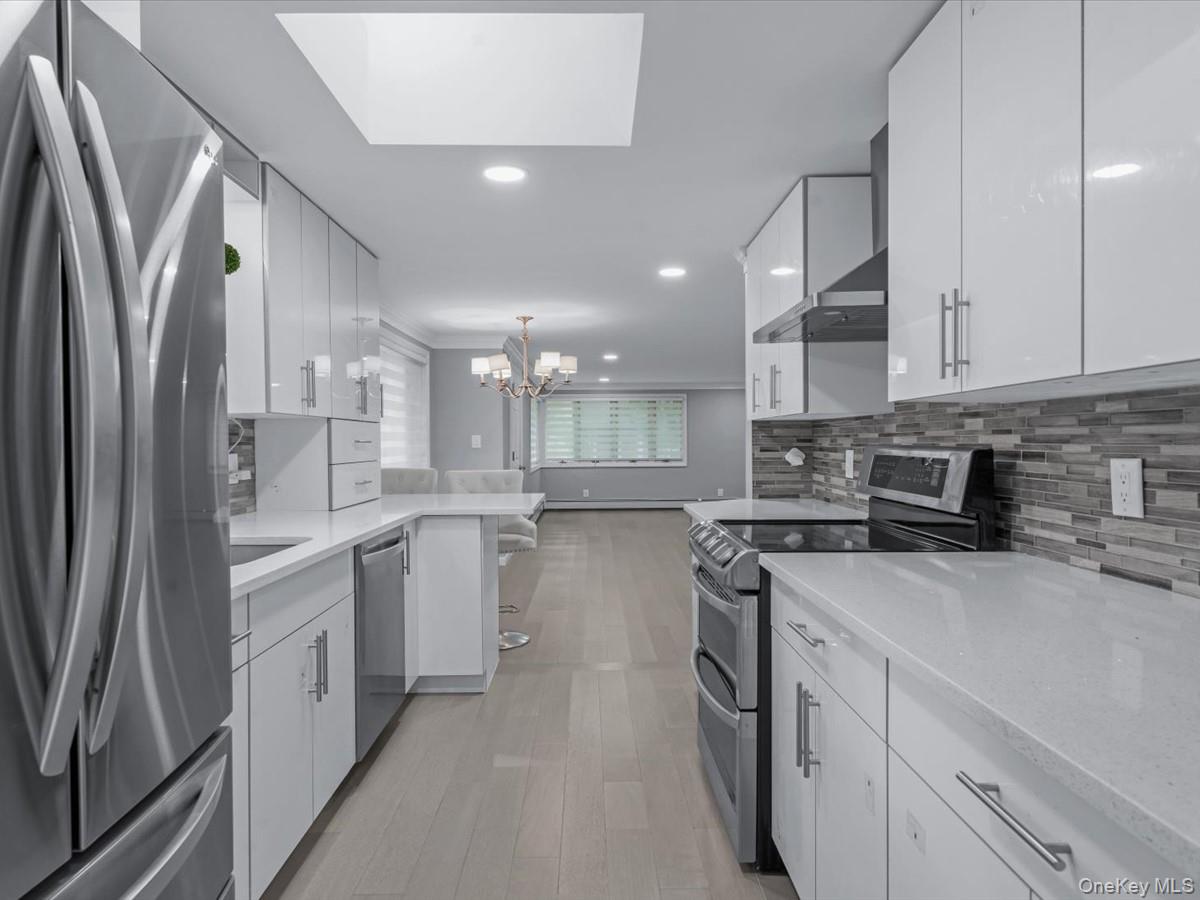 19 Ridge Drive East Roslyn, NY 11576 - Photo 12 of 33 a kitchen with white cabinets and refrigerator