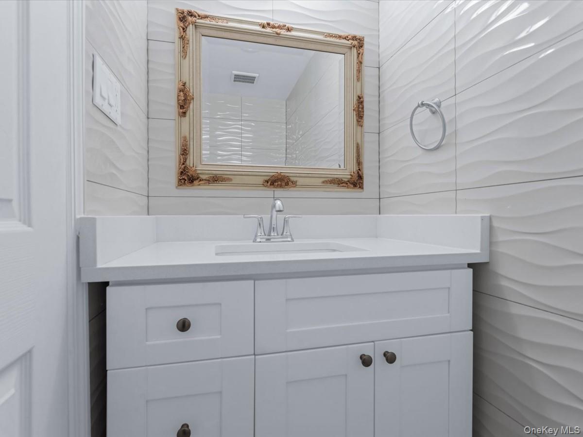 19 Ridge Drive East Roslyn, NY 11576 - Photo 28 of 33 a bathroom with a sink vanity and a mirror