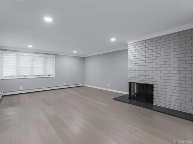 an empty room with wooden floor and fireplace