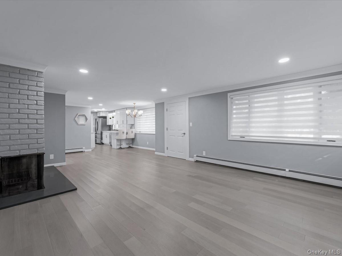 19 Ridge Drive East Roslyn, NY 11576 - Photo 7 of 33 an empty room with wooden floor a fireplace and windows