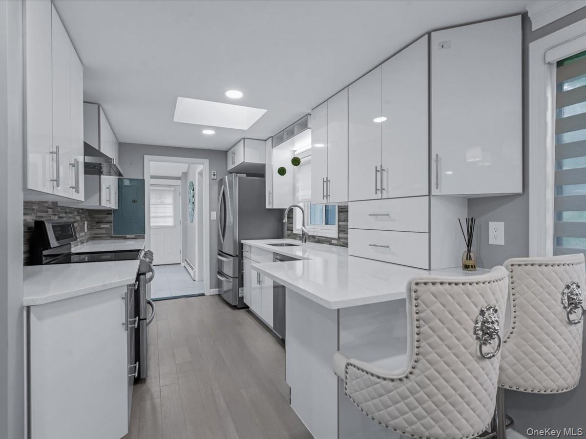 19 Ridge Drive East Roslyn, NY 11576 - Photo 10 of 33 a kitchen with granite countertop white cabinets and white appliances