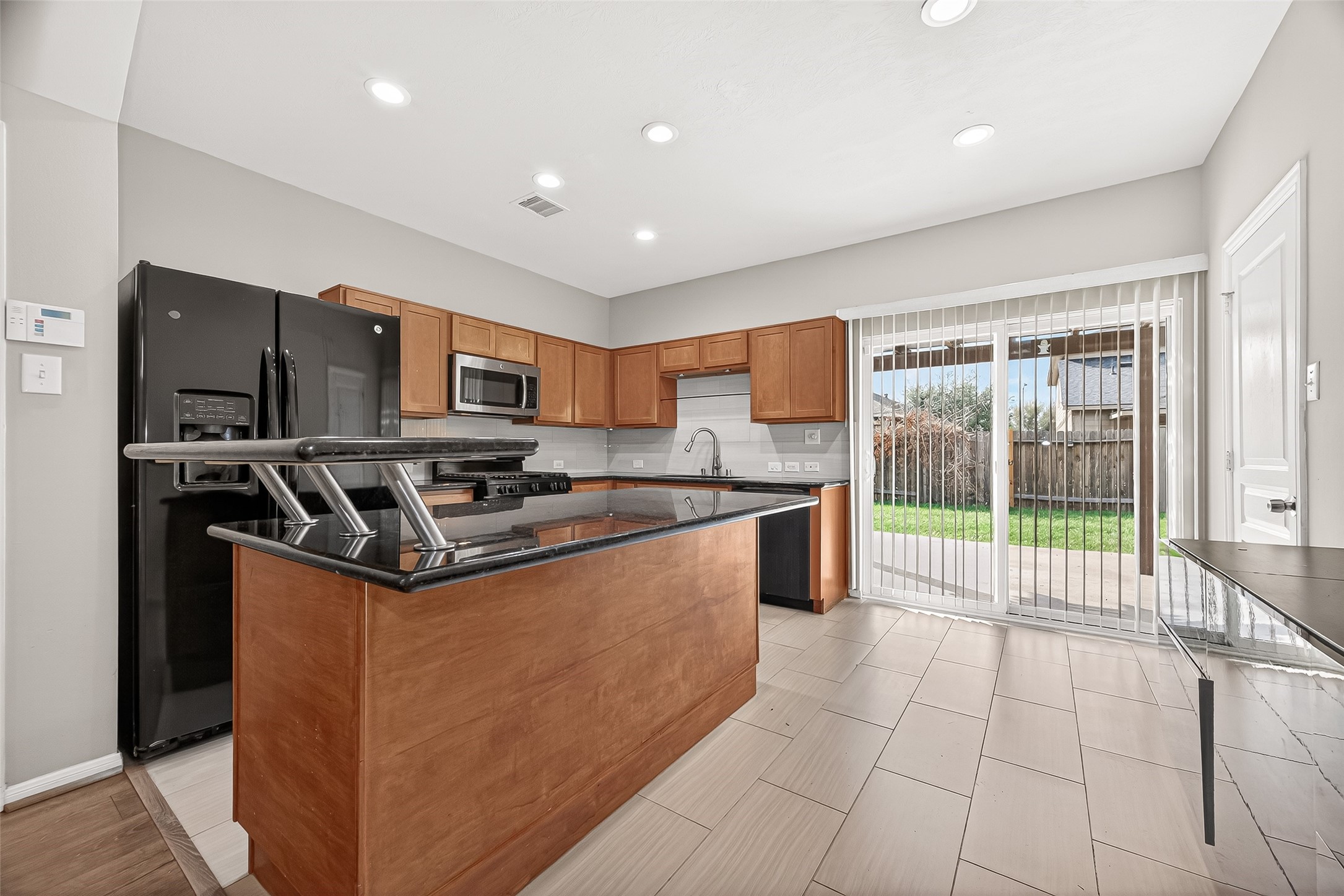 11211 Riata Canyon Drive Cypress, TX 77433 - Photo 13 of 33 a kitchen with stainless steel appliances granite countertop a refrigerator a sink a stove top oven and a large window
