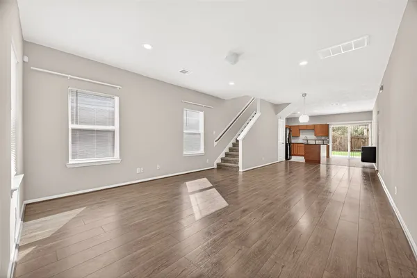 a kitchen with stainless steel appliances granite countertop a refrigerator a sink a stove top oven and a large window