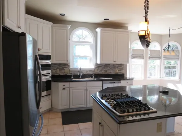 a kitchen with stainless steel appliances granite countertop a stove a sink and a refrigerator