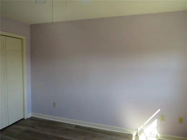 an empty room with wooden floor and closet