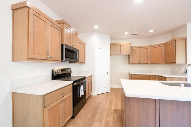 a kitchen with a sink a stove top oven a counter space and cabinets