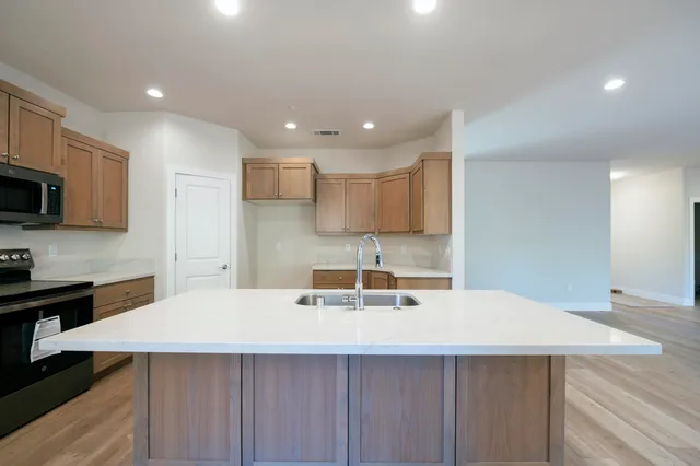 a kitchen with a sink a microwave and cabinets