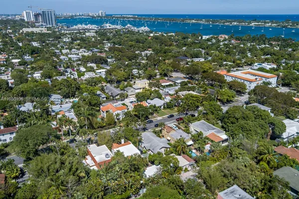 an aerial view of residential houses with outdoor space and trees