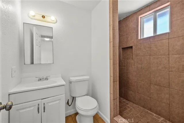 a bathroom with a toilet sink vanity and mirror